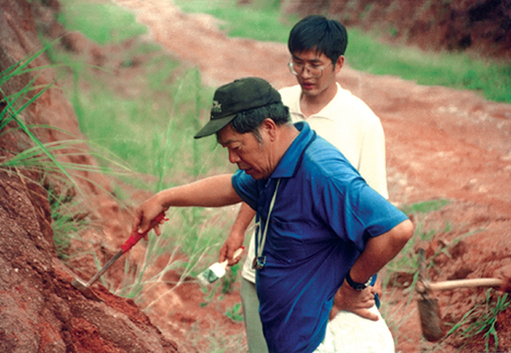 1999年8月，董枝明和学生吕君昌在河源市区黄山村恐龙骨骼化石出土点考察.jpg